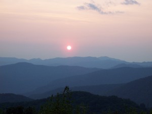pink skies and the sun hanging over purple rows of mountains