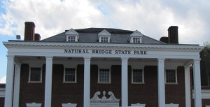 a red brick building with white pillars and "Natural Bridge State Park" across the top