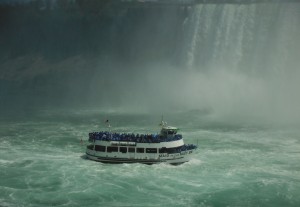 ferry boat in front of falls surrounded by mist